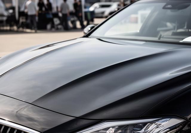 屋外カーショー会場で展示される黒い高級車の磨き上げられたボンネット
